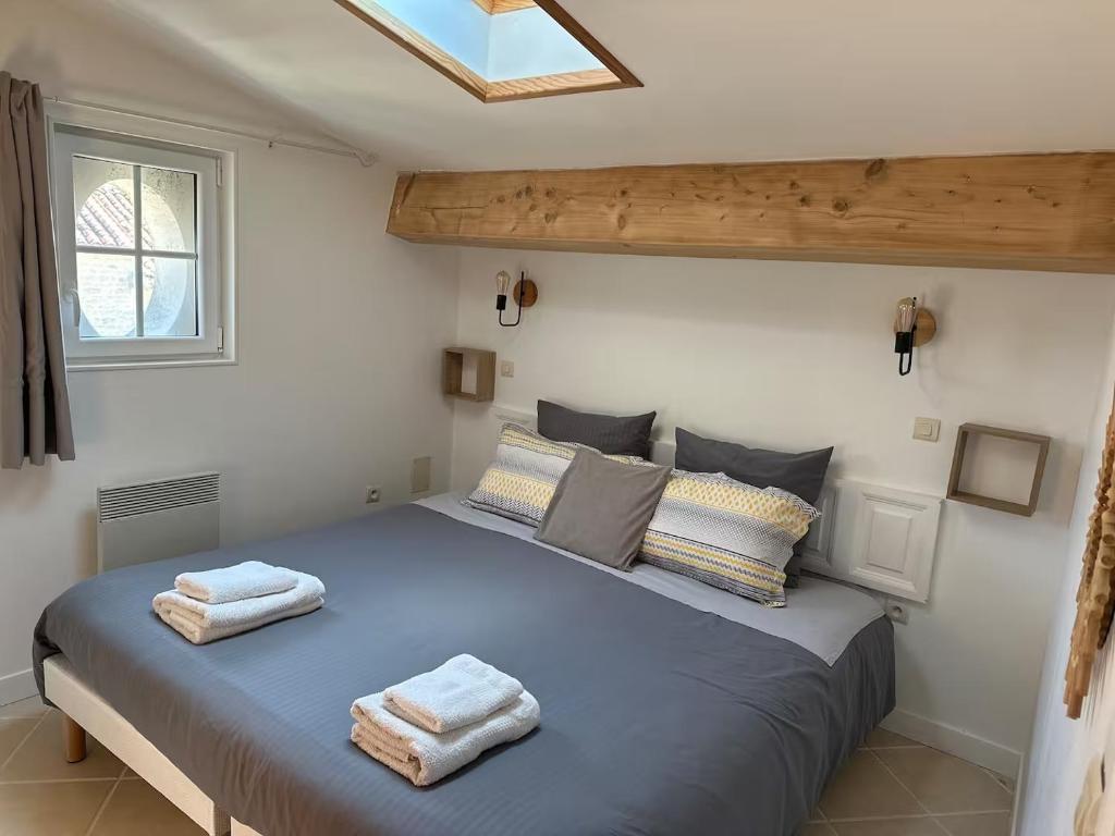 a bedroom with a blue bed with towels on it at Gîte Chez Tiramisù avec piscine in Coivert