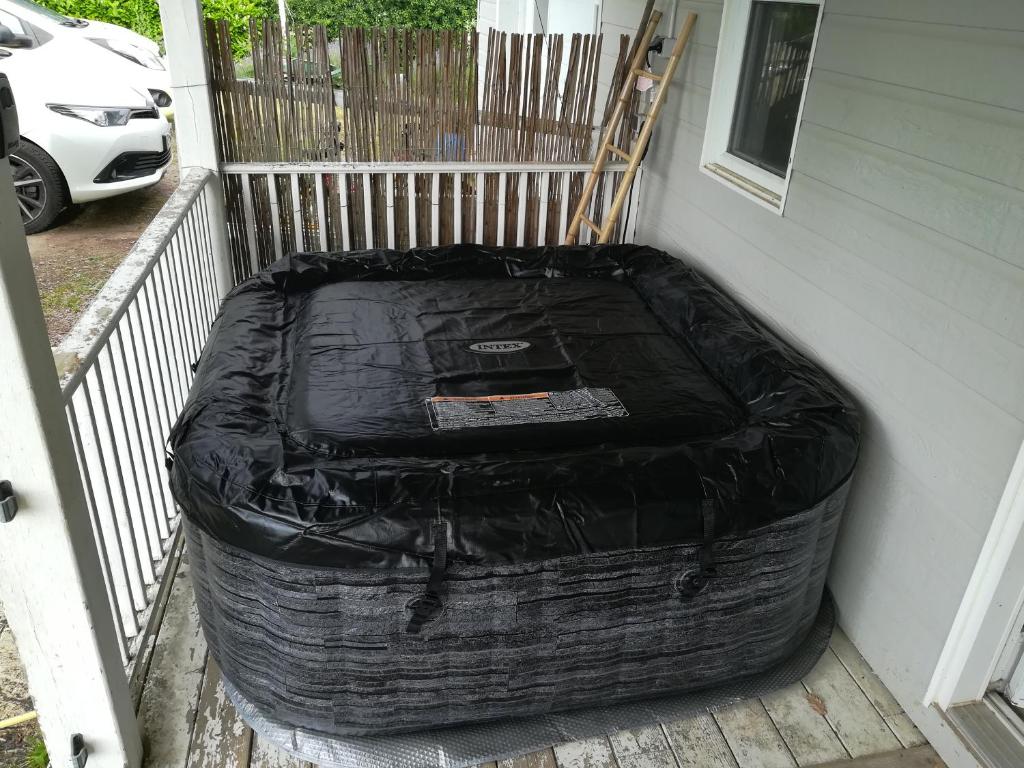 une grande valise noire assise sur une terrasse couverte dans l'établissement Notre nid d'amour - jacuzzi, piscine, billard, bar extérieur, terrain de boules, à Saint-Sernin-du-Bois