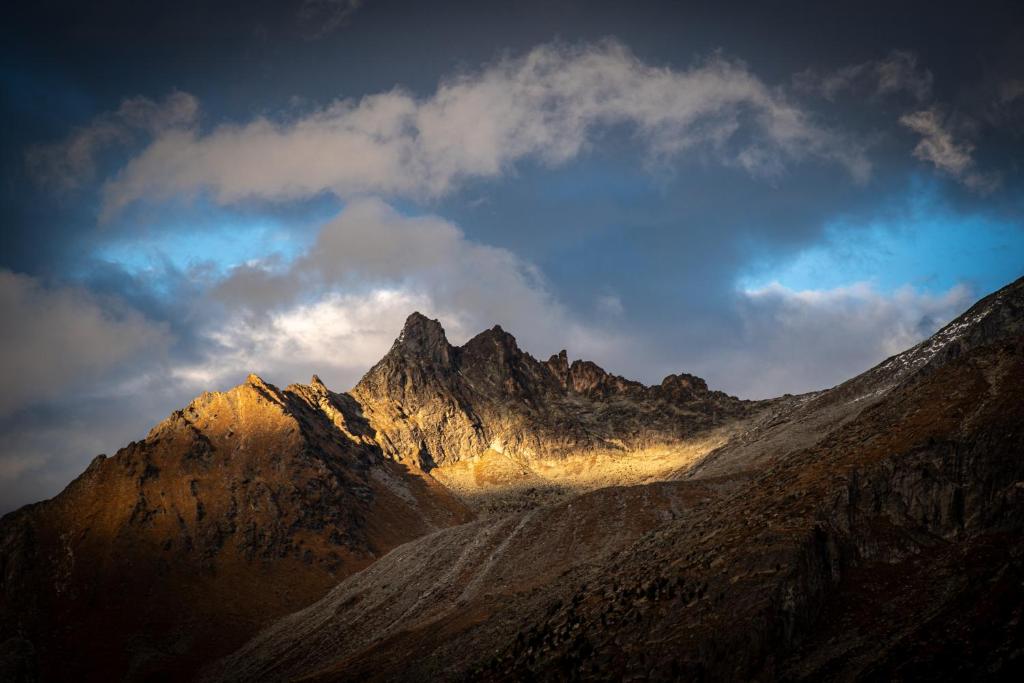 a mountain range with the sun shining on it at Séjour Edelweiss in Arolla