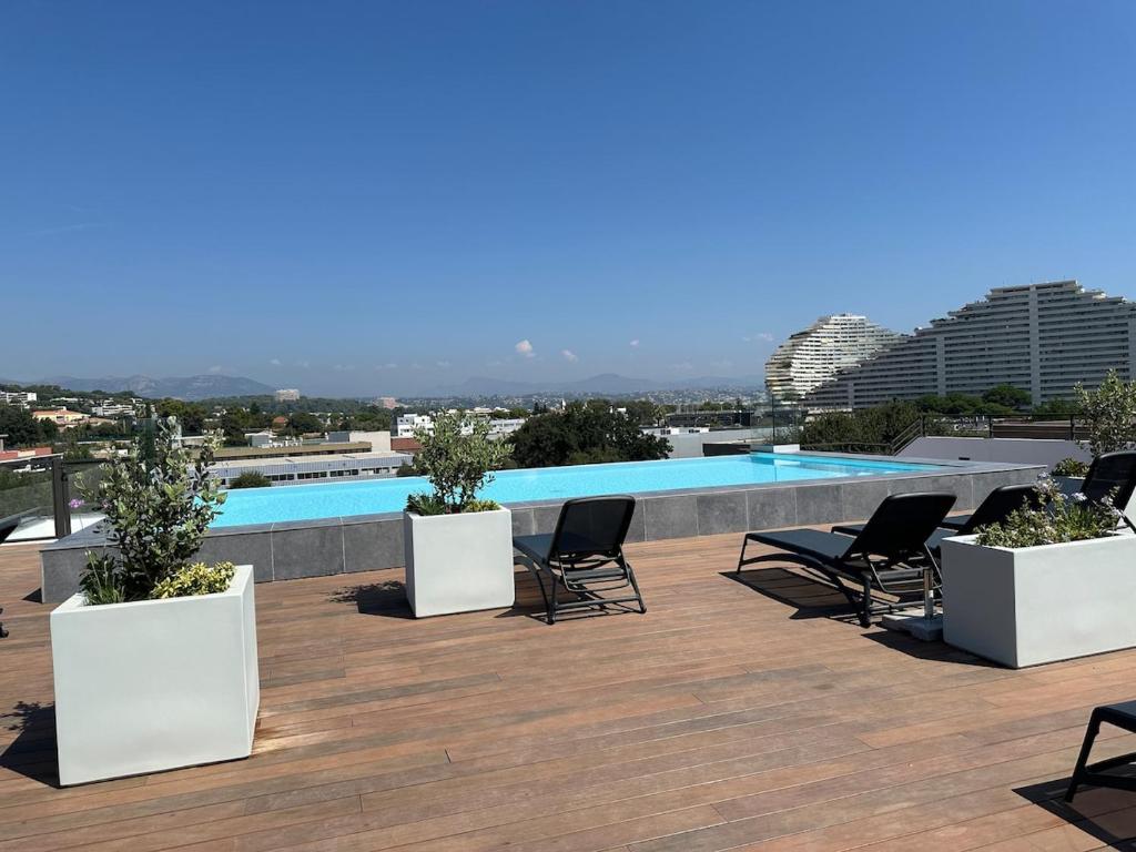 un patio avec des chaises et une piscine sur le toit dans l'établissement Rooftop Pool, à Villeneuve-Loubet