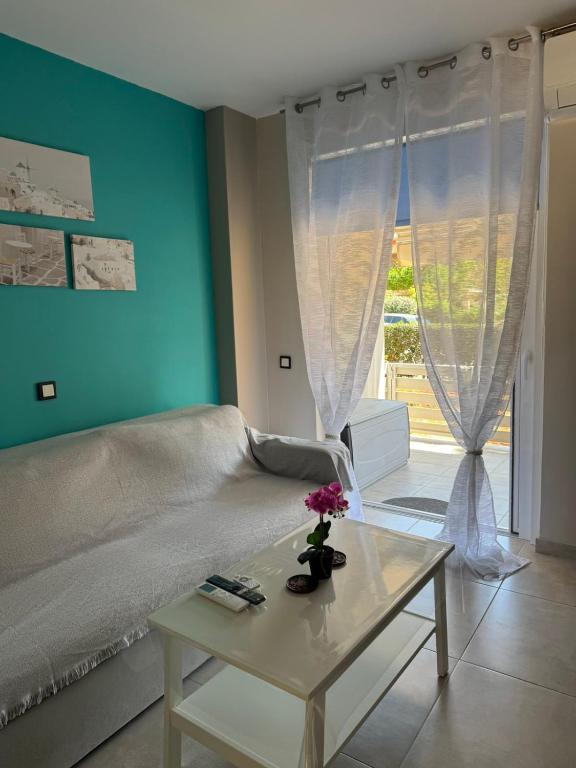a living room with a bed and a table with flowers on it at Bovis Apartments #2 in Porto Rafti