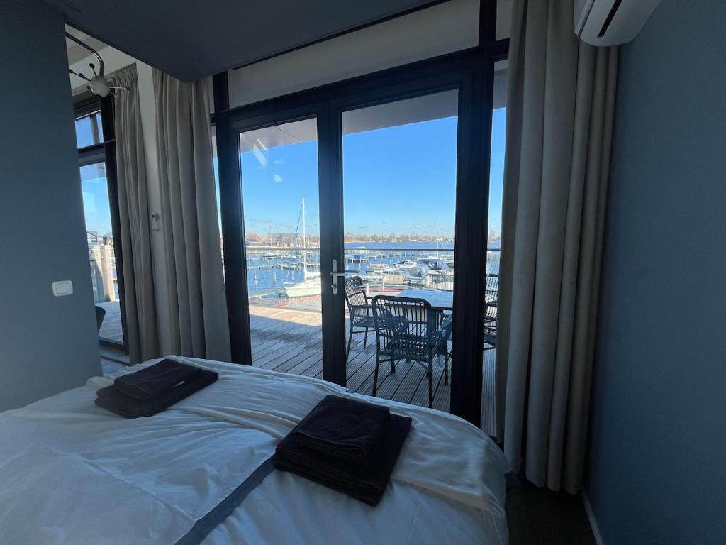 Un dormitorio con una cama y vista a un balcón. en Appartement Oan it Pikmar, en Grou