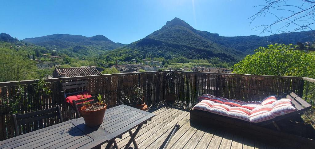 d'un balcon avec un banc et une vue sur les montagnes. dans l'établissement Maison et jardin coeur de village, à Sumène