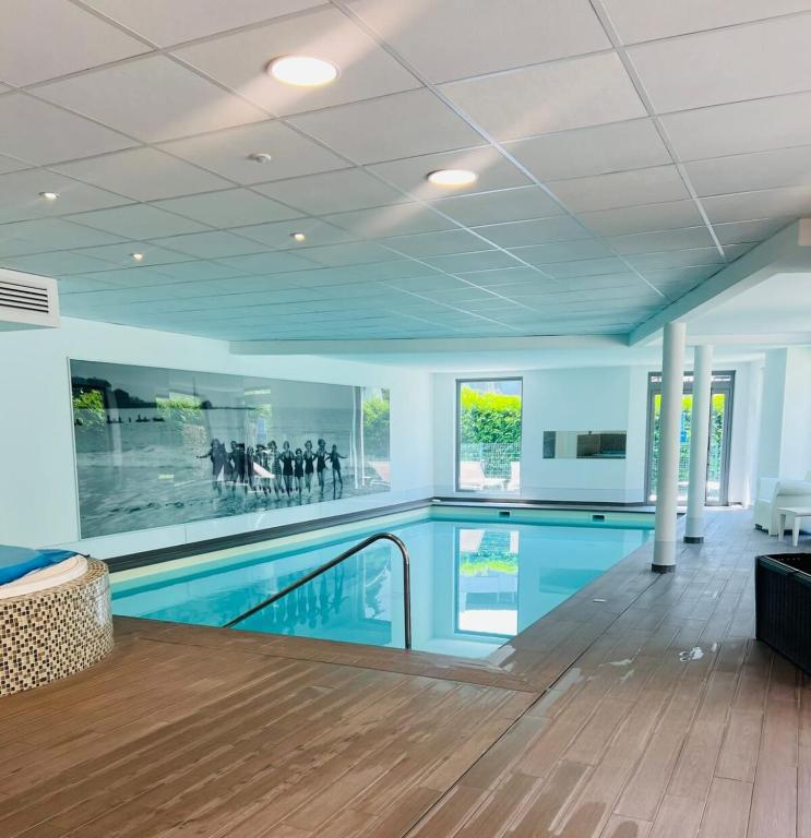 a large swimming pool in a building with a pool at Résidence 3 bord du lac logement T3 piscine spa in Aix-les-Bains