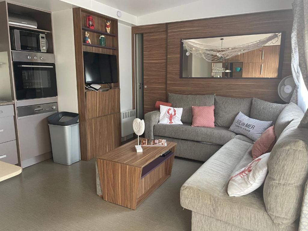 un salon avec un canapé et une table dans l'établissement Pleasant Mobile Home Ba680 - Siblu Bonne Anse La Palmyre, aux Mathes