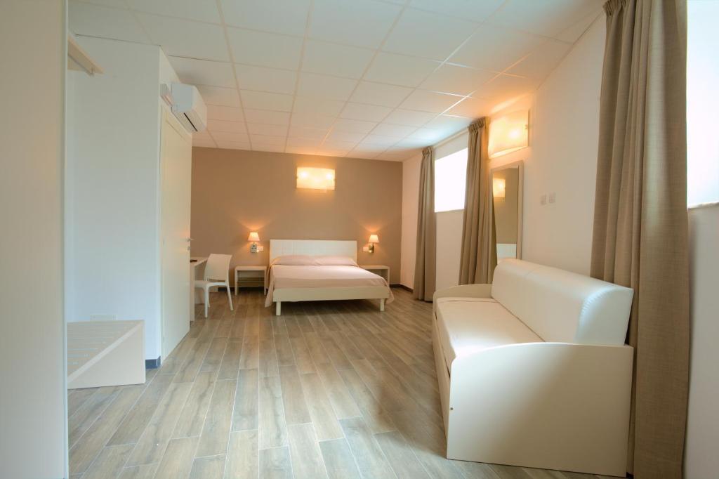een ziekenhuiskamer met een bed en een bank bij Sabbia d'Oro locanda & beach in Bonassola