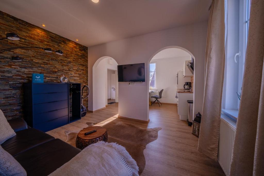 a living room with a tv and a brick wall at Aurora Schaar 2 in Wilhelmshaven