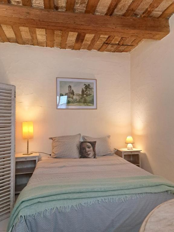 a bedroom with a large bed with two lamps at Au coeur d'Uzès in Uzès