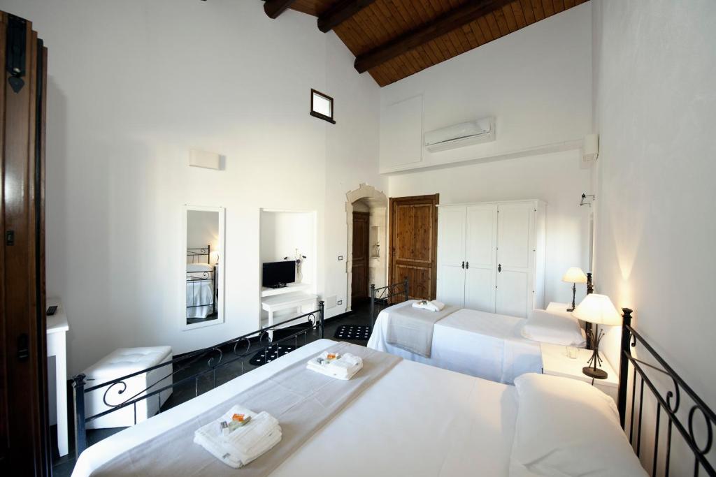 a bedroom with three beds and a television in it at La Casa di Matilde in Ragusa