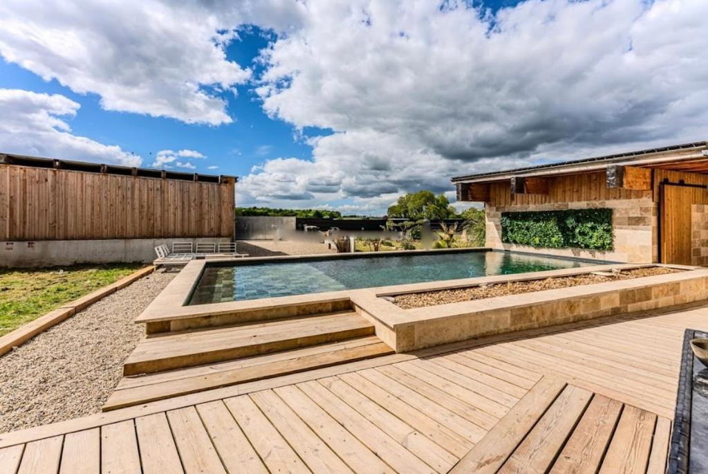une piscine avec des marches en bois et une terrasse en bois dans l'établissement Maison clôturée, piscine privée, à Saint-Pierre-de-Bat