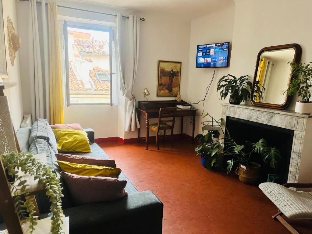 salon z kanapą i kominkiem w obiekcie Le cosy du Panier w Marsylii