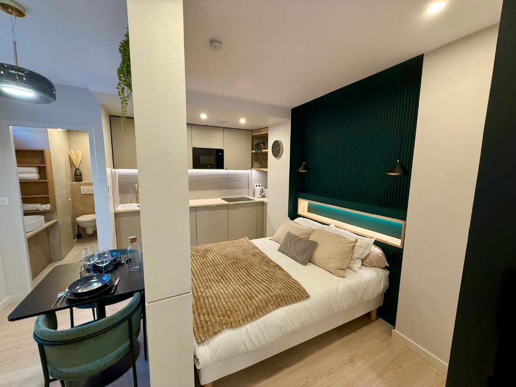 une chambre avec un lit et un bureau dans une pièce dans l'établissement Calme & Élégance Studio de Charme proche Centre, à Aix-les-Bains