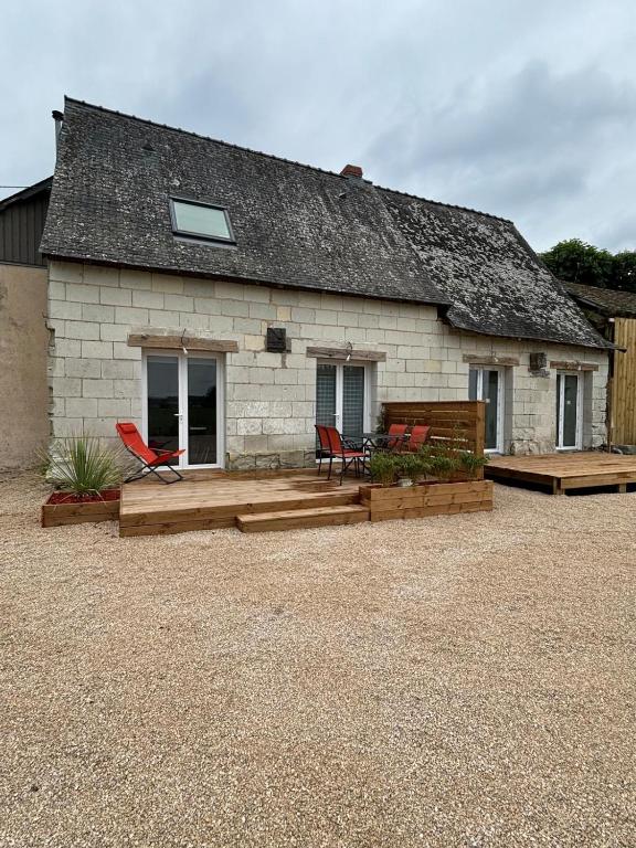 une maison avec 2 chaises et une terrasse dans l'établissement les deux tilleuls, à Les Rosiers