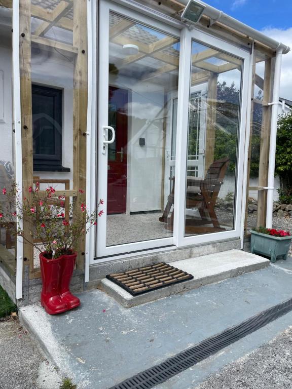 a glass door of a house with a red boot at Marta Studio Apartment in Ennistymon