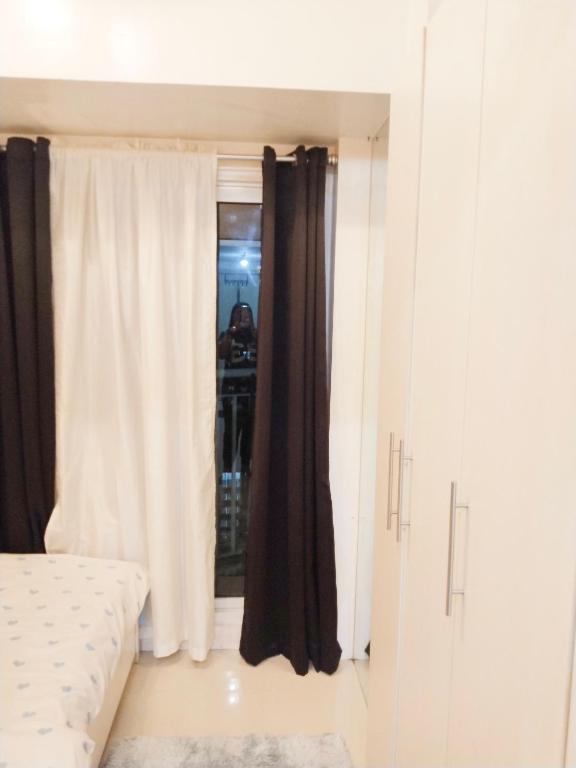 a bedroom with a bed and a window at Maria's staycation in Manila