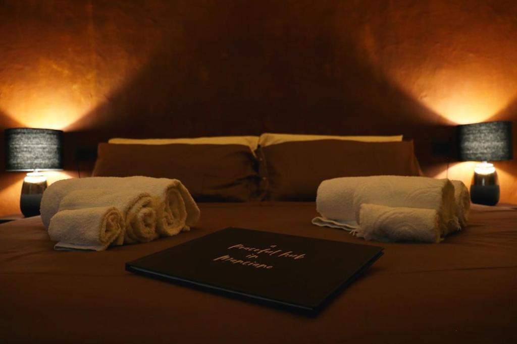 a bed with two towels and two lamps on it at Peaceful Hub Saturnia in Manciano