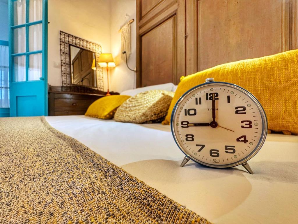 a clock sitting on the edge of a bed at El Conventillo de San Roque in San Roque