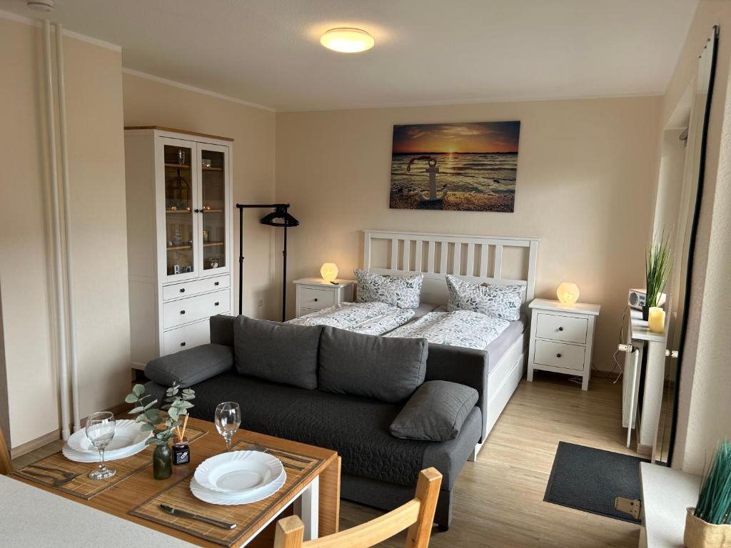 a living room with a couch and a bed at Ferienwohnung Ritthoff Perlebucht - mit Strandkorb am Meer und kostenloser Eintritt ins Schwimmbad in Büsum