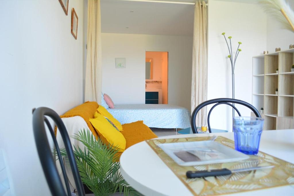a living room with a table and a bed at Bleu Horizon in Hyères