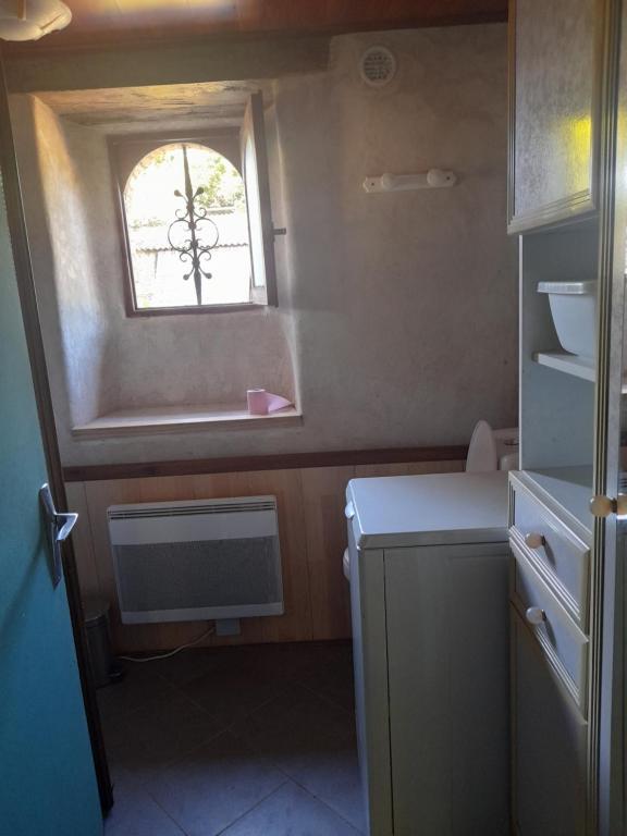 une petite cuisine avec un évier et une fenêtre dans l'établissement 9kms de clisson studio dans petite ferme bio, à Maisdon-sur-Sèvre