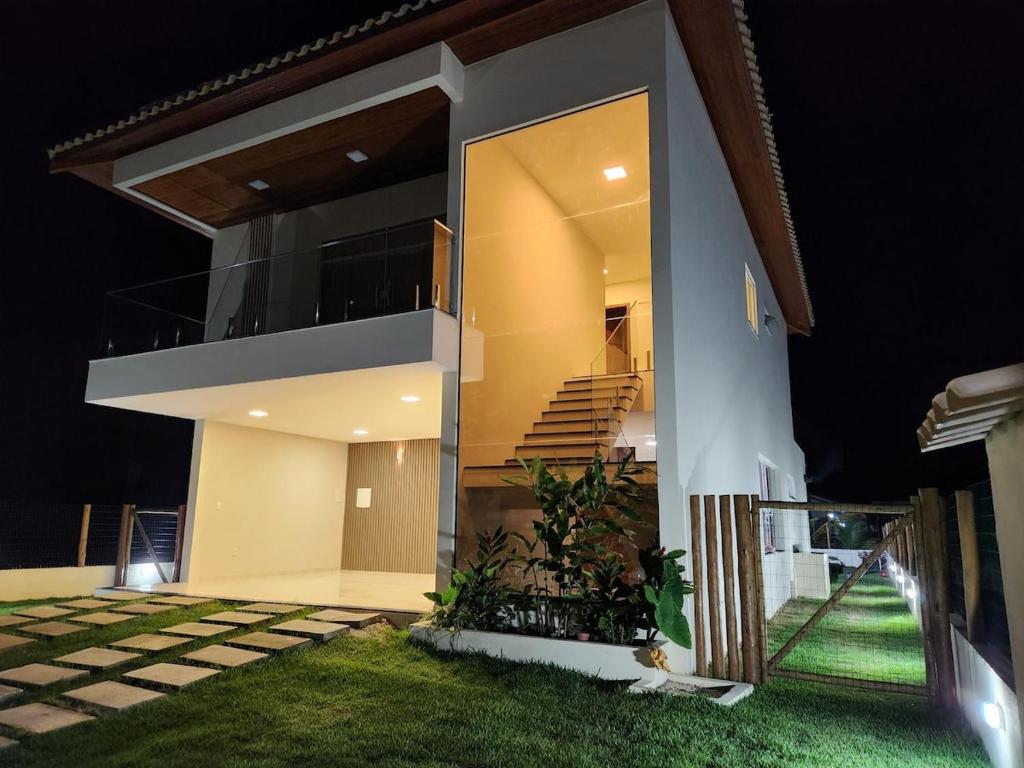 a modern house with a balcony at night at Taipu House Fantástica com piscina em condomínio in Barra Grande