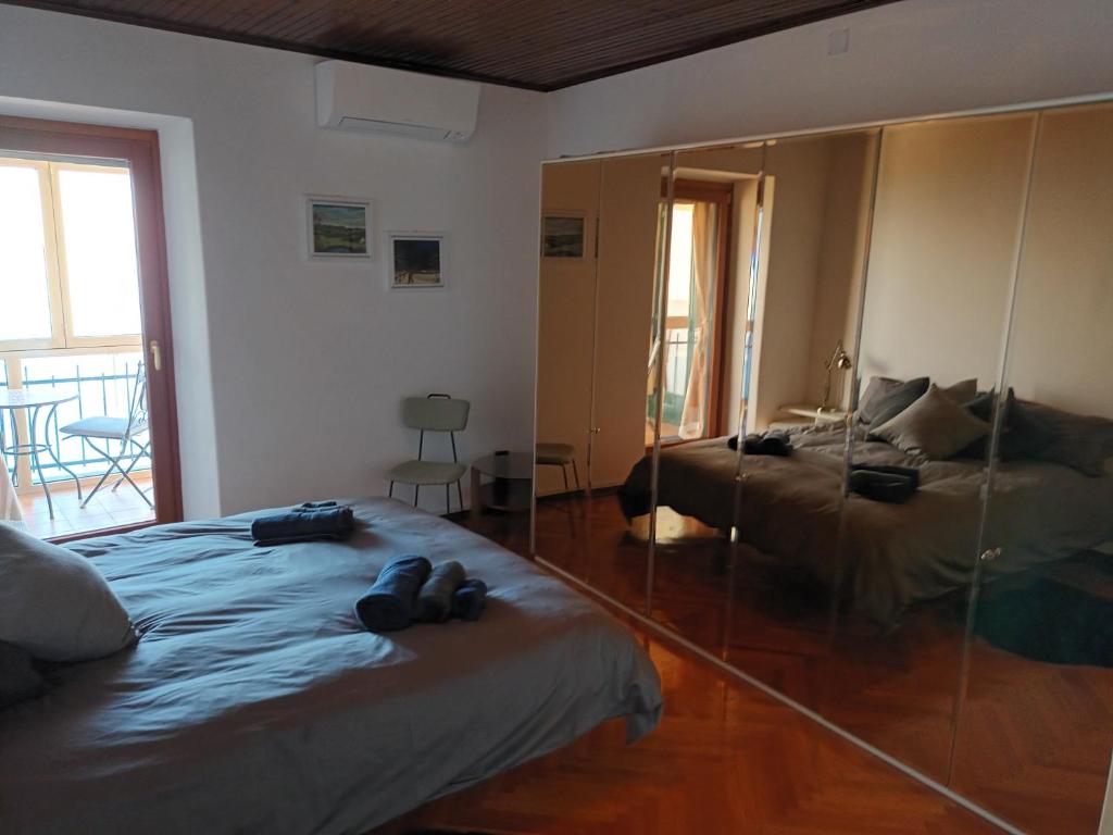 a bedroom with two beds and a large mirror at Apartment Trieste Casa Vacanze NATASCIA in Trieste