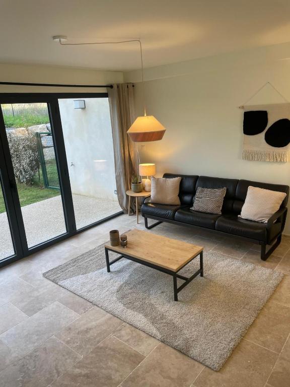 - un salon avec un canapé noir et une table basse dans l'établissement Le Cinglé du Ventoux, à Malaucène