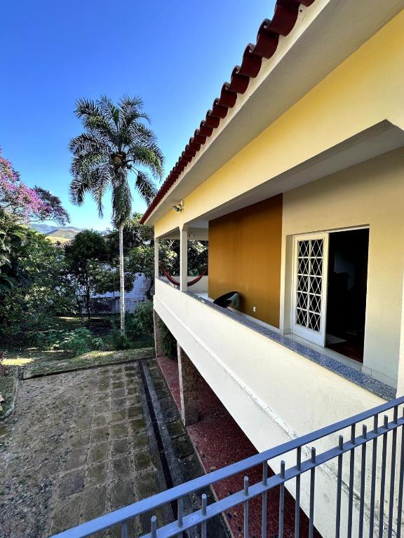 a balcony of a house with a palm tree at Casa Amarela in Conservatória