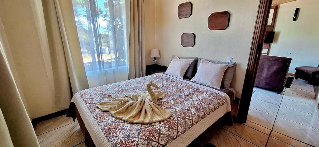 een slaapkamer met een bed met een standbeeld erop bij Alojamientos Norte y Sur in Monteverde Costa Rica