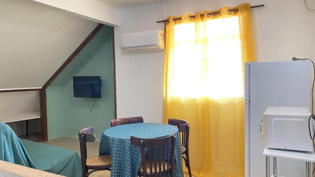 a room with a table and chairs and a window at Appartement moderne à Remire-Montjoly avec balcon, 60 m² in Rémire-Camp