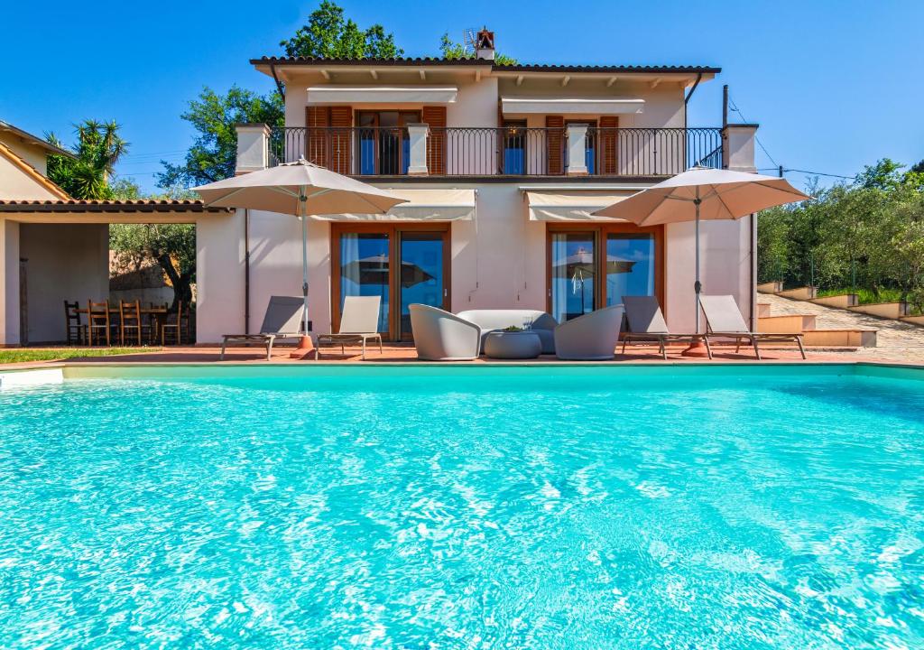 a villa with a swimming pool in front of a house at Villa con Piscina immersa nel Verde - Montecarlo - Horizonte Selections in Montecarlo