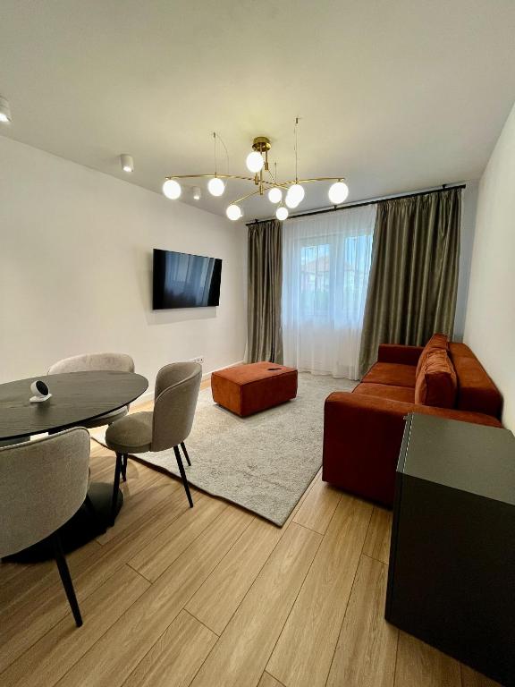 a living room with a bed and a dining room at Central Residence in Mediaş