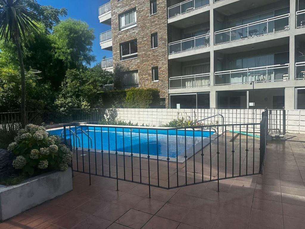 a swimming pool in front of a apartment building at Apartamento con vista al Rio y frente a la playa in Colonia del Sacramento