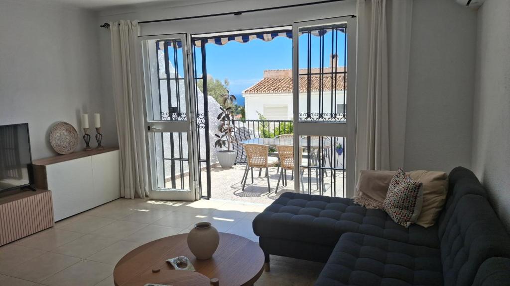 een woonkamer met een bank en een tafel en een balkon bij Carmen Casa Helena in Nerja