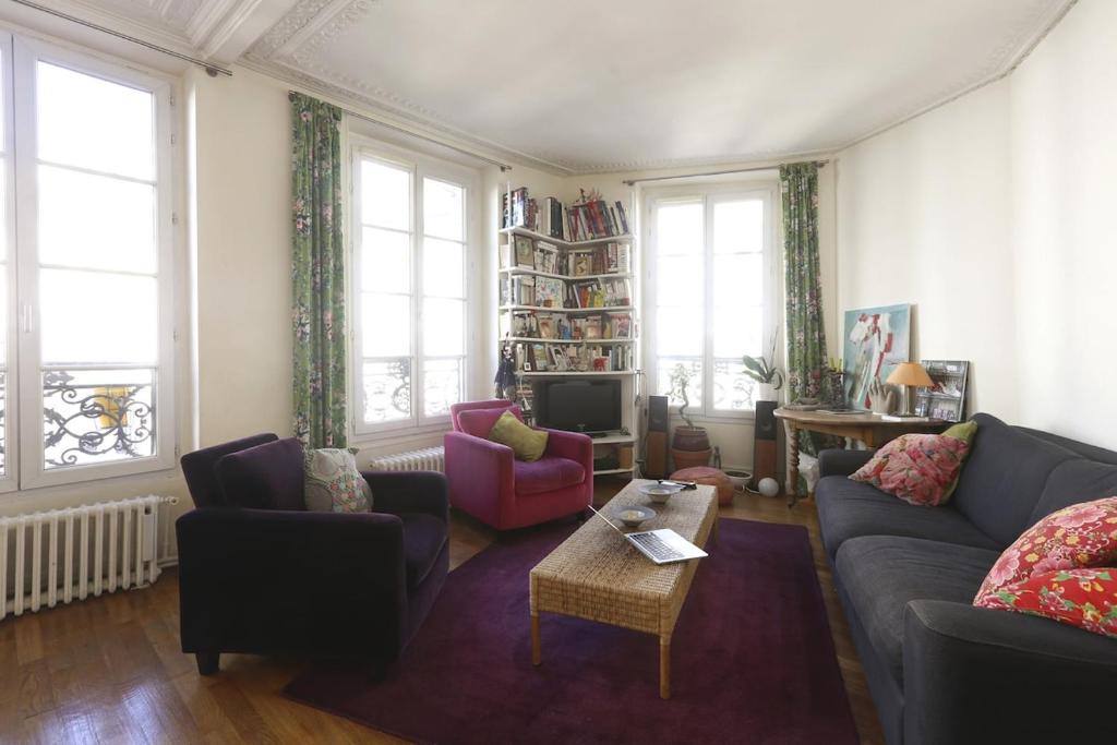 un salon avec un canapé, des chaises et une télévision dans l'établissement Typical Parisian apartment 70sqm Downtown, à La Celle-sous-Gouzon