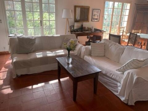 un salon avec un canapé blanc et une table basse dans l'établissement Beautiful house, sea view, access to beach path 7mn, à Roquebrune-sur Argens