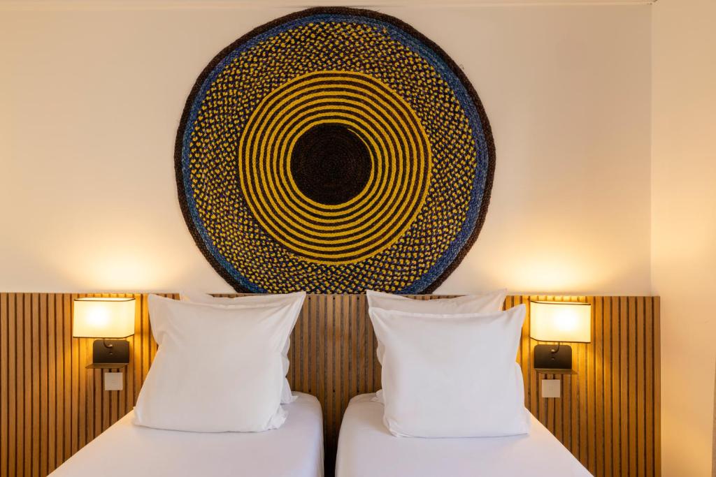 deux lits dans une chambre avec un tableau au mur dans l'établissement Hôtel Victoria Châtelet, à Paris