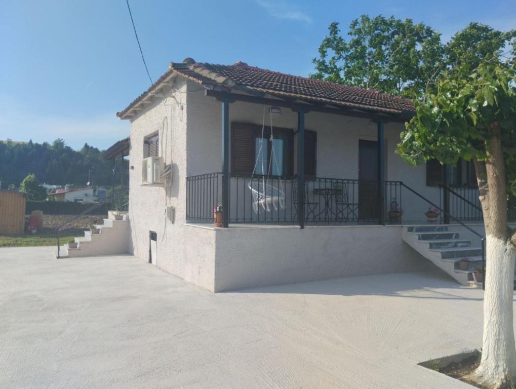 a small house with a balcony and a tree at Vagia in Tríkala