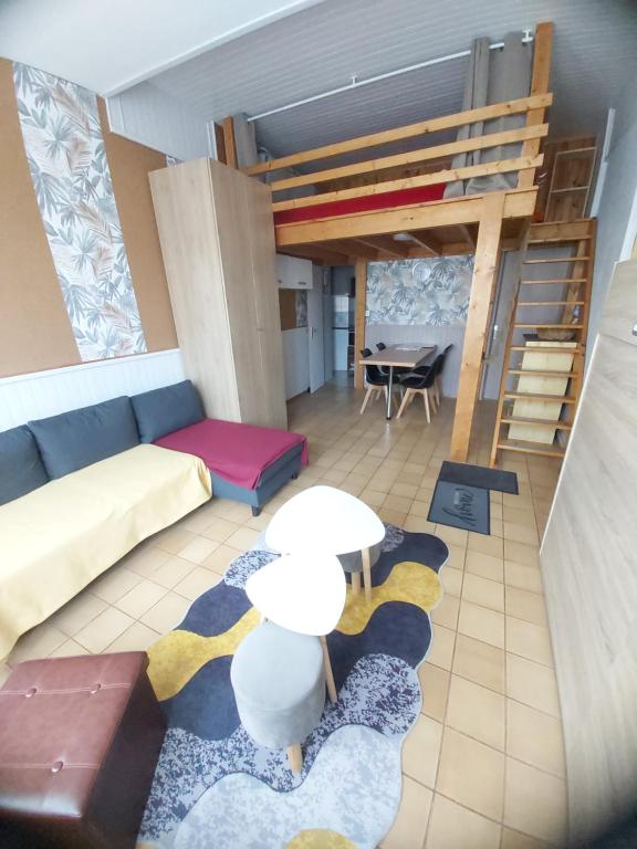 - un salon avec un canapé et une mezzanine dans l'établissement Studio 2 à 4 personnes avec garage privé, à Le Mont-Dore