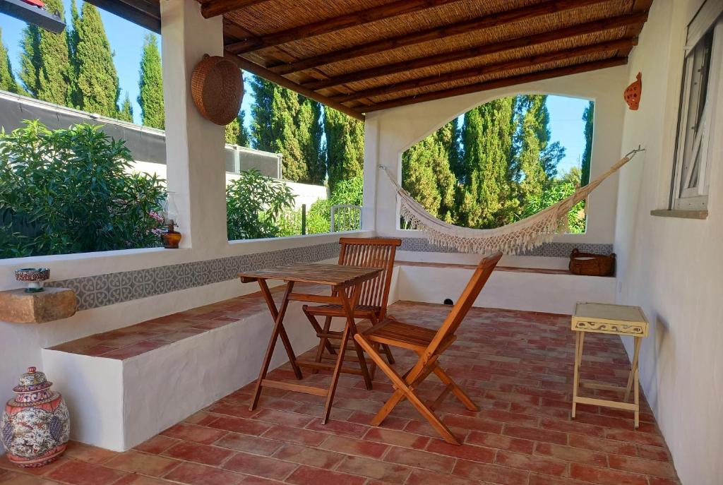 un portico con amaca, tavolo e sedie di Vila Kuka 2 a Tavira