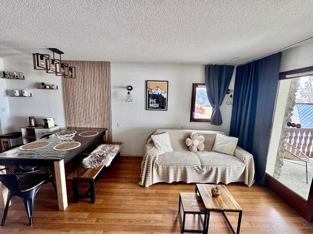 une chambre avec un lit et une table dedans dans l'établissement Ski, confort famille, appartement Cosy, Vue montagne,piscine,parking, à Bagnères-de-Bigorre