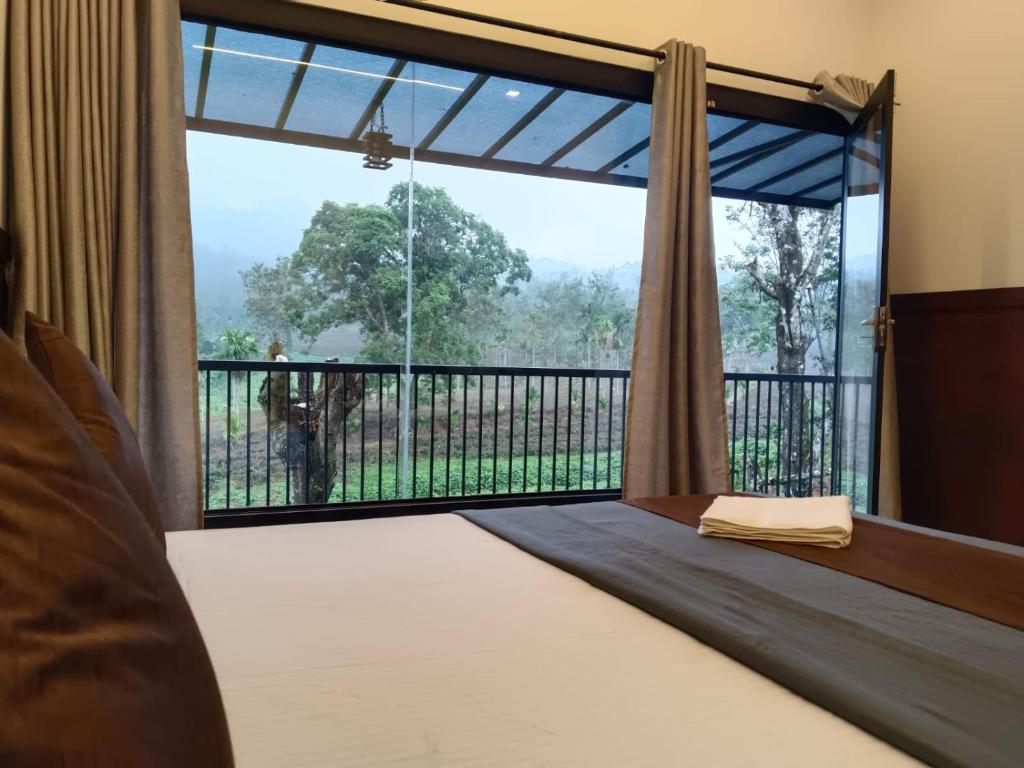 a bedroom with a bed and a large window at The Tree House in Vythiri
