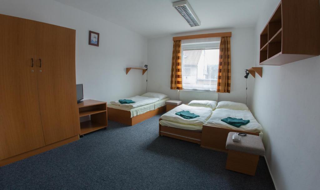 a small room with two beds and a window at Sportovní Centrum Semily in Semily