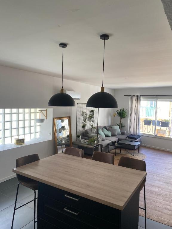 un salon avec une table et des chaises dans l'établissement Confort & tranquillité à deux pas des restos et de la gare, à Perpignan