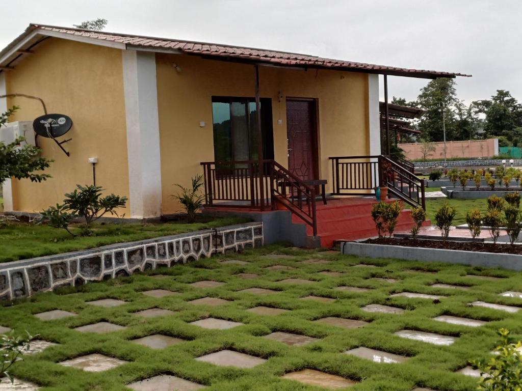 a house with a lawn in front of it at The Malshej Mist in Ghātghar