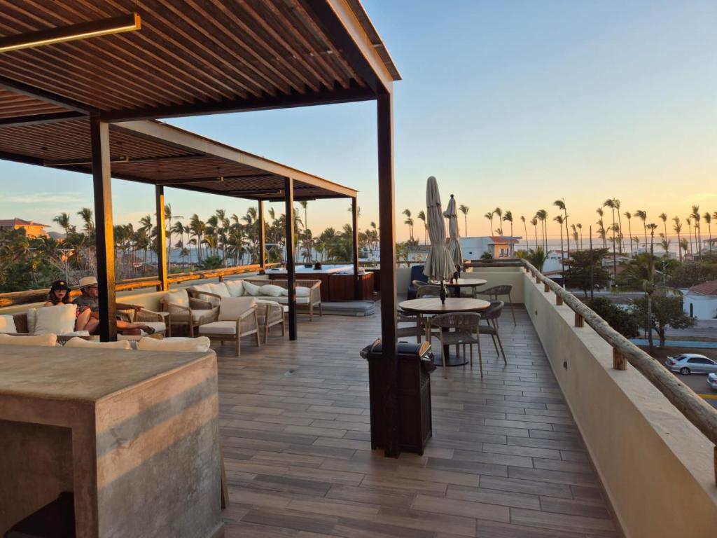 a patio with tables and chairs on a roof at New Oceanfront Apartment in Mazatlán