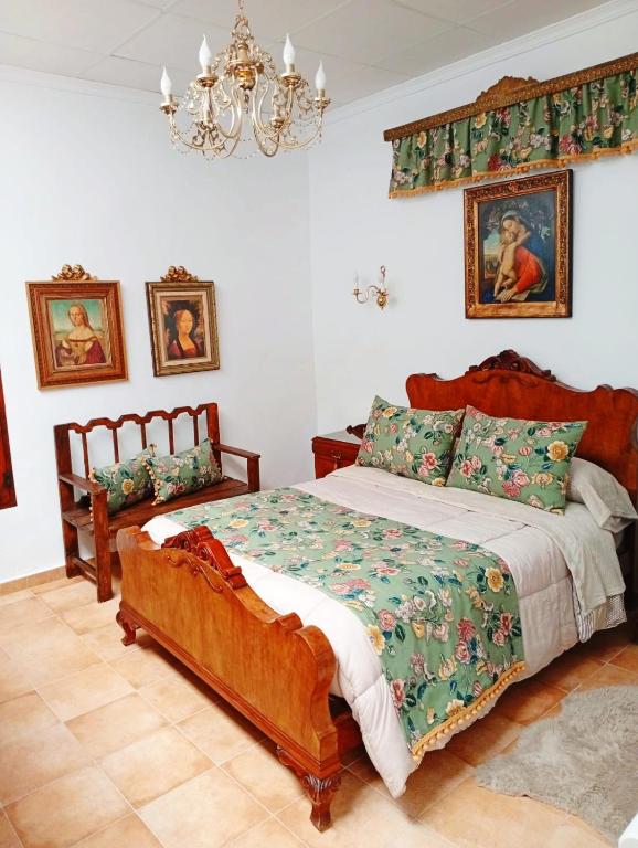 1 dormitorio con cama y lámpara de araña en Casa Rural en San Carlos del Valle- Doña Gumersinda, en San Carlos del Valle