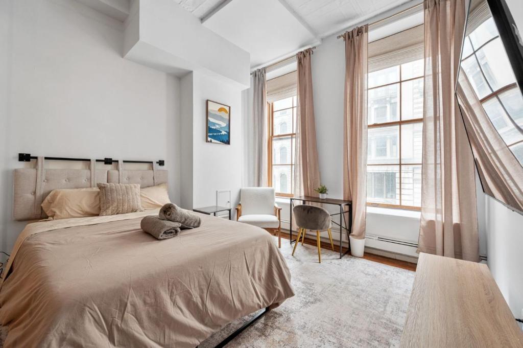 a white bedroom with a large bed and windows at Soho Fancy 4 Bedroom 2000 square feet Loft in New York