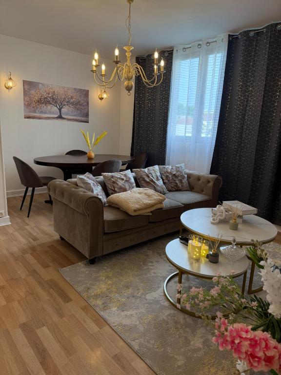 un salon avec un canapé et une table dans l'établissement Beautiful and modern apartment close to Paris, à Villeneuve-la-Garenne