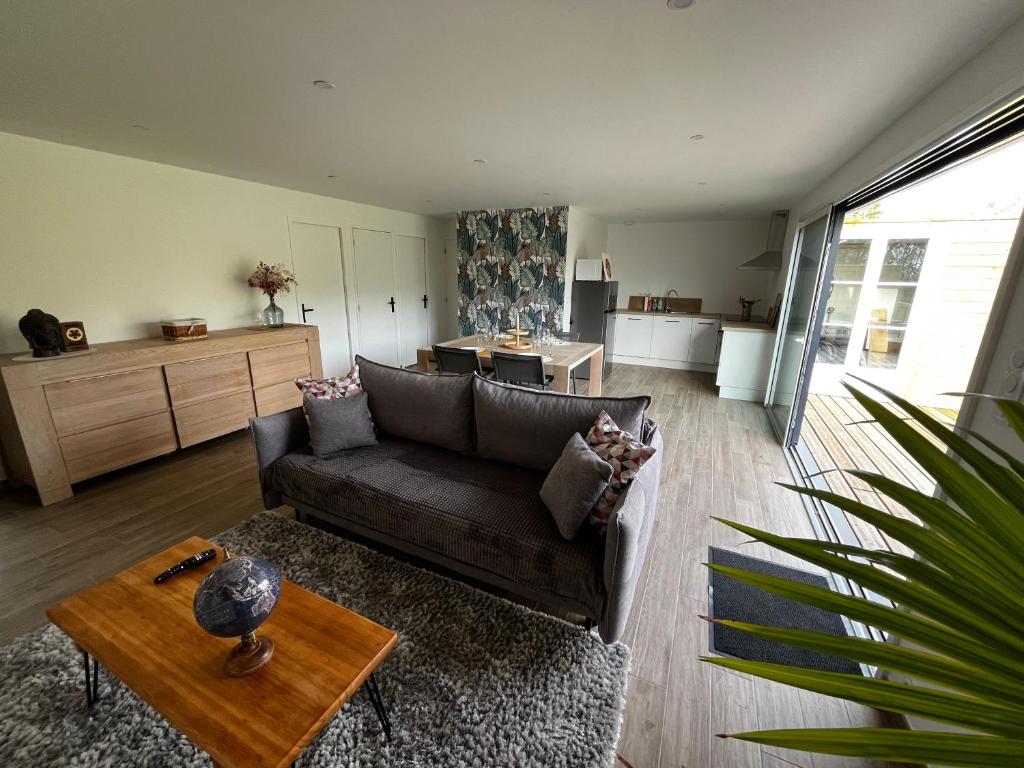 un salon avec un canapé et une table dans l'établissement Maison à la campagne, à Baguer-Pican